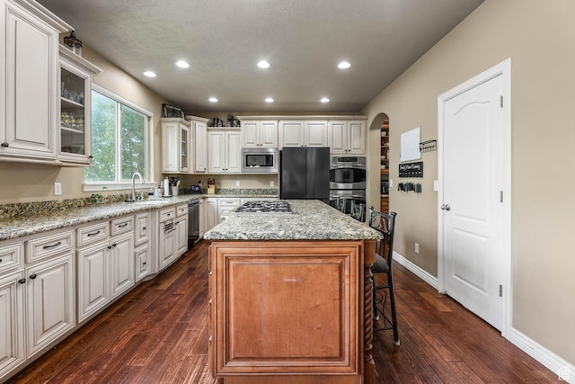 14346 S Fort Duchesne Cv, Herriman, UT 84096 - kitchen featuring appliances with stainless steel finishes, recessed lighting, arched walkways, a kitchen island, and a breakfast bar area