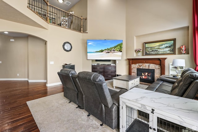 14346 S Fort Duchesne Cv, Herriman, UT 84096 - living room featuring a glass covered fireplace, arched walkways, wood finished floors, and a towering ceiling