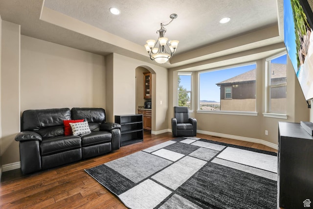 14346 S Fort Duchesne Cv, Herriman, UT 84096 - living area featuring a tray ceiling, arched walkways, hardwood / wood-style floors, a chandelier, and recessed lighting