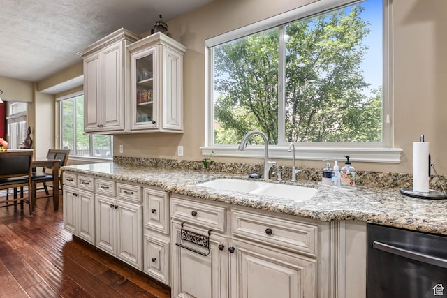 14346 S Fort Duchesne Cv, Herriman, UT 84096 - kitchen with stainless steel dishwasher, healthy amount of natural light, dark wood finished floors, and glass insert cabinets