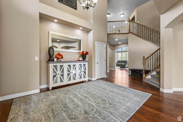 14346 S Fort Duchesne Cv, Herriman, UT 84096 - entrance foyer featuring arched walkways, stairs, wood finished floors, and a high ceiling