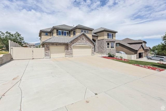 14346 S Fort Duchesne Cv, Herriman, UT 84096 - view of front of home with stone siding, driveway, stucco siding, and a gate