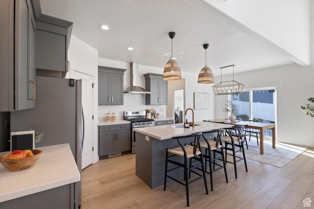 2437 E Ember Dr, Draper, UT 84020 - kitchen featuring wall chimney exhaust hood, stainless steel range, light wood-type flooring, gray cabinetry, and recessed lighting