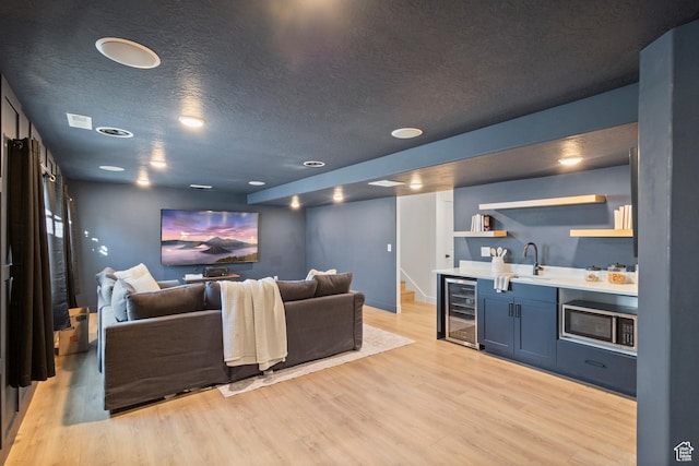 2437 E Ember Dr, Draper, UT 84020 - living area with wine cooler, wet bar, light wood-style floors, a textured ceiling, and stairway