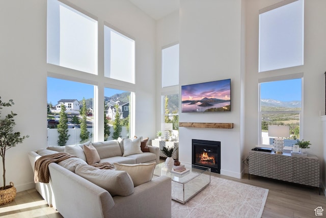 2437 E Ember Dr, Draper, UT 84020 - living room featuring a towering ceiling, healthy amount of natural light, a glass covered fireplace, and light wood-type flooring