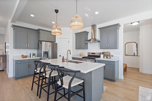 2437 E Ember Dr, Draper, UT 84020 - kitchen featuring wall chimney exhaust hood, stainless steel appliances, light countertops, a kitchen bar, and light wood-style flooring