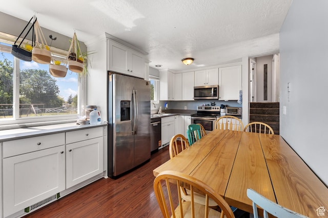 2601 N 720 W, Clinton, UT 84015 - kitchen featuring stainless steel appliances, healthy amount of natural light, a textured ceiling, white cabinets, and dark wood-style floors