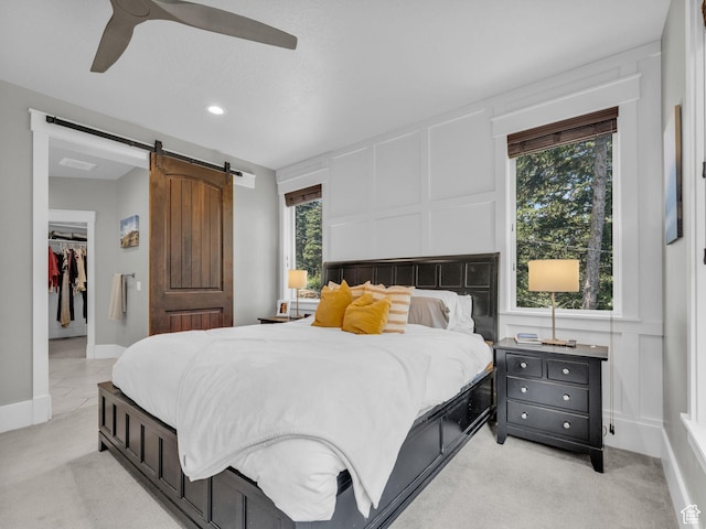 485 Parkview Dr, Summit Park, UT 84098 - bedroom with a decorative wall, a barn door, multiple windows, a walk in closet, and light colored carpet