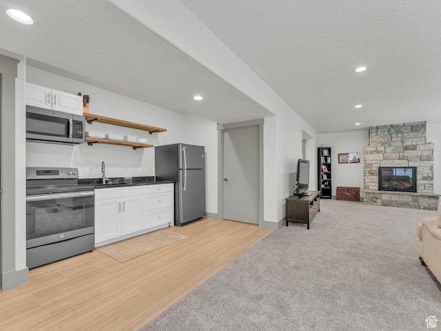 485 Parkview Dr, Summit Park, UT 84098 - kitchen featuring appliances with stainless steel finishes, open floor plan, white cabinets, dark countertops, and light wood-style flooring