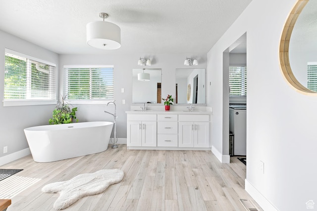 520 990 N, Pleasant Grove, UT 84062 - full bathroom with double vanity, wood finished floors, a freestanding bath, and a textured ceiling
