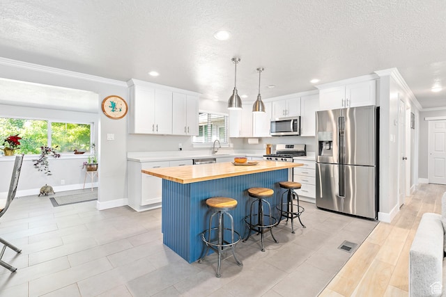 520 990 N, Pleasant Grove, UT 84062 - kitchen featuring stainless steel appliances, wood counters, crown molding, a kitchen breakfast bar, and recessed lighting