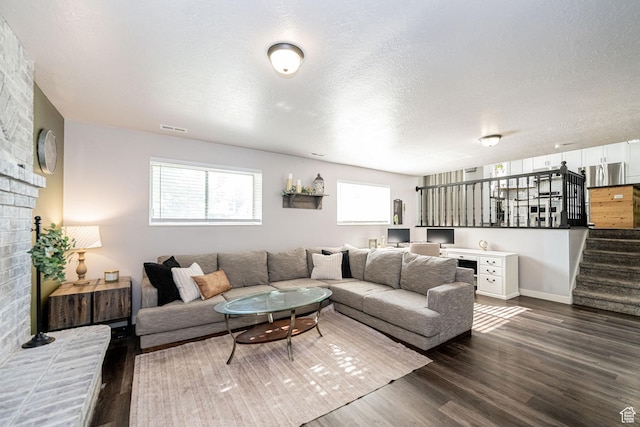 4922 S 2925 W, Roy, UT 84067 - living room featuring dark wood finished floors, stairway, a textured ceiling, and a brick fireplace
