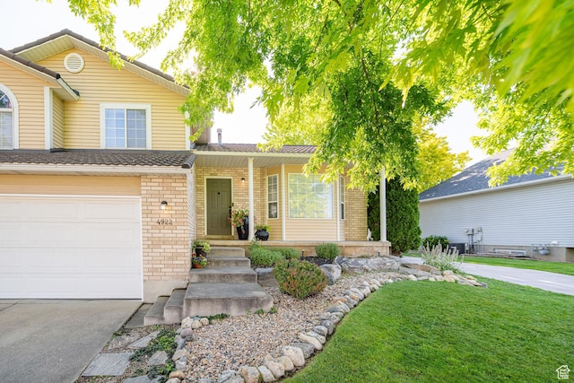 4922 S 2925 W, Roy, UT 84067 - view of front facade with brick siding, a garage, driveway, a porch, and a front yard