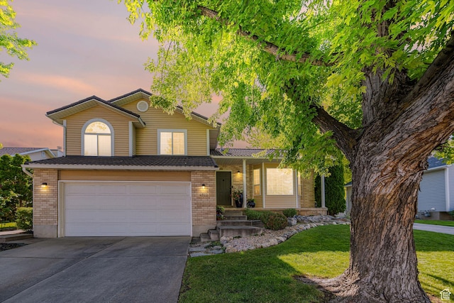 4922 S 2925 W, Roy, UT 84067 - view of front of home with brick siding, driveway, an attached garage, and a lawn