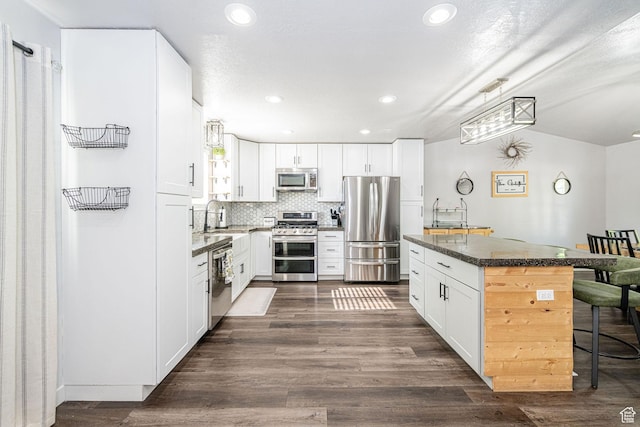 4922 S 2925 W, Roy, UT 84067 - kitchen featuring appliances with stainless steel finishes, a breakfast bar area, a kitchen island, recessed lighting, and white cabinets