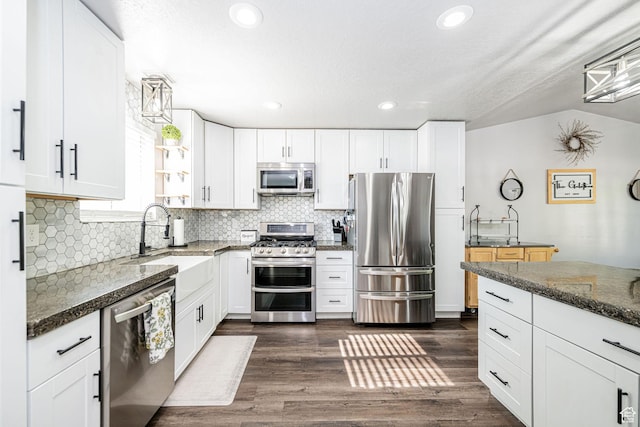 4922 S 2925 W, Roy, UT 84067 - kitchen with appliances with stainless steel finishes, backsplash, white cabinetry, dark stone counters, and recessed lighting