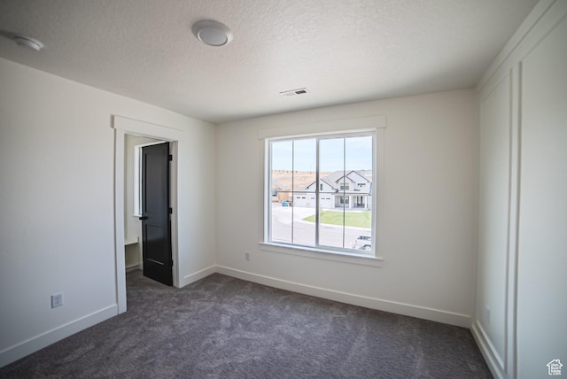 7169 W Moorepark Pl, West Jordan, UT 84081 - spare room with dark colored carpet, a textured ceiling, and a smoke detector