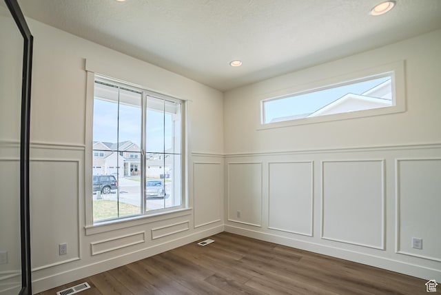 7169 W Moorepark Pl, West Jordan, UT 84081 - empty room featuring a decorative wall, dark wood-type flooring, a wainscoted wall, and recessed lighting