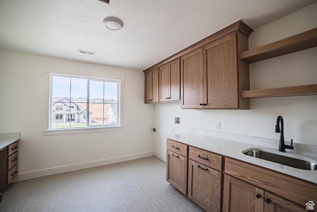 7169 W Moorepark Pl, West Jordan, UT 84081 - kitchen with open shelves, light countertops, light carpet, and brown cabinetry