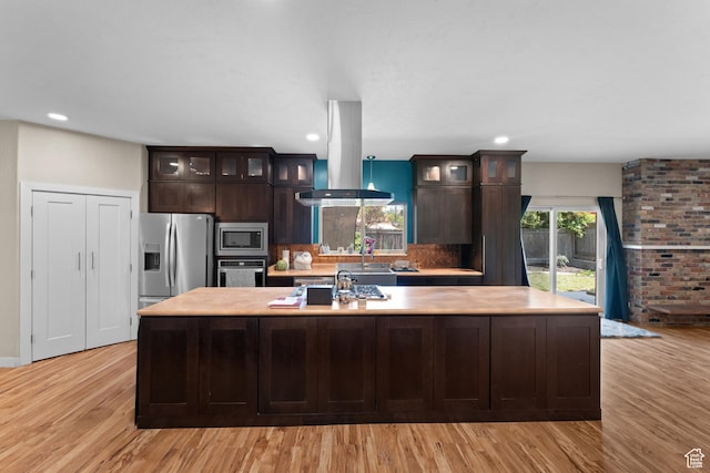 4281 S Nielsen Way, West Valley City, UT 84119 - kitchen featuring appliances with stainless steel finishes, island exhaust hood, light countertops, a kitchen island with sink, and dark brown cabinetry