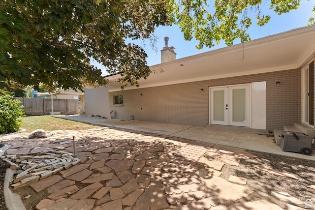 4281 S Nielsen Way, West Valley City, UT 84119 - rear view of property featuring brick siding, a patio area, a chimney, and french doors