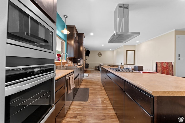 4281 S Nielsen Way, West Valley City, UT 84119 - kitchen featuring ventilation hood, appliances with stainless steel finishes, light wood-style floors, dark brown cabinetry, and a center island