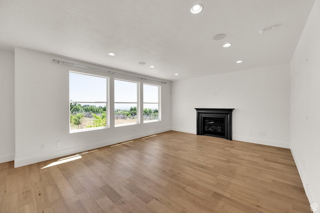 1378 E Orchard Ridge Ln, Kaysville, UT 84037 - unfurnished living room featuring a fireplace, recessed lighting, and light wood-type flooring