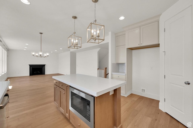 1378 E Orchard Ridge Ln, Kaysville, UT 84037 - kitchen featuring stainless steel microwave, a fireplace, a chandelier, recessed lighting, and light wood finished floors