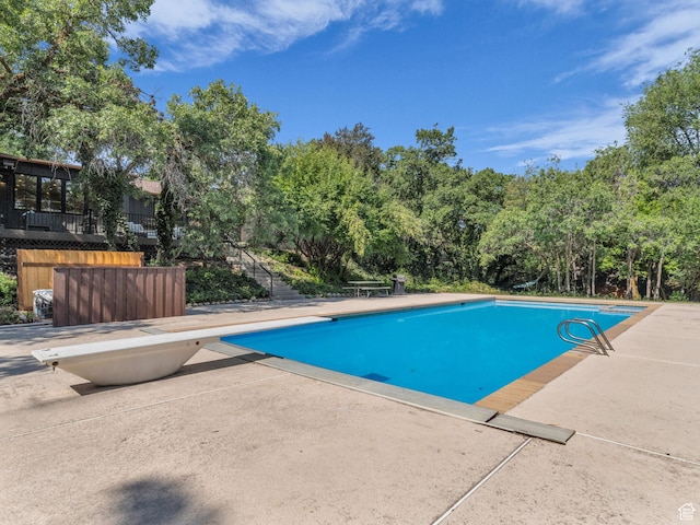 1499 E River Oaks Dr, Sandy, UT 84093 - outdoor pool with a diving board, a patio area, and view of wooded area