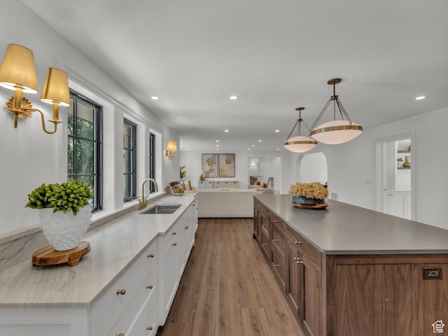 1499 E River Oaks Dr, Sandy, UT 84093 - kitchen with a large island, white cabinets, open floor plan, wood finished floors, and recessed lighting