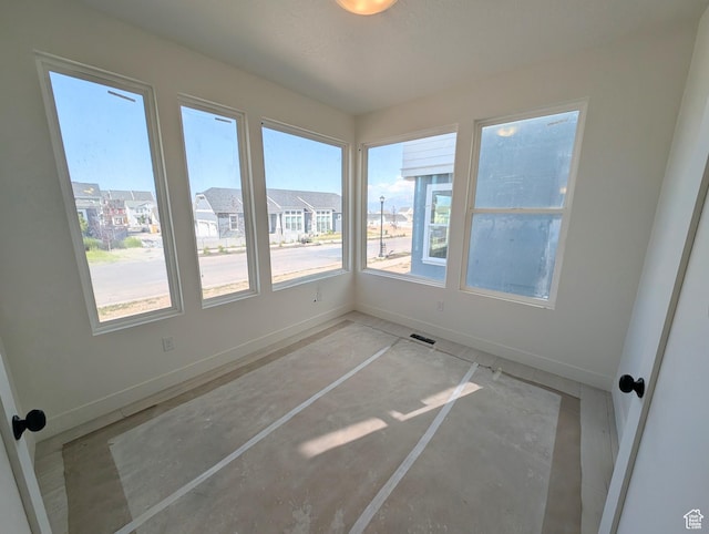 7083 W Granbury Dr S Unit 256, South Jordan, UT 84009 - unfurnished sunroom with baseboards and unfinished concrete floors