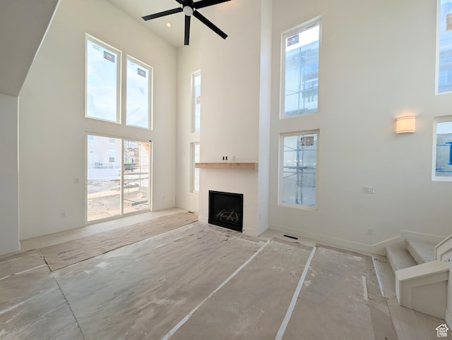 7083 W Granbury Dr S Unit 256, South Jordan, UT 84009 - unfurnished living room with a high ceiling, a fireplace, and a ceiling fan