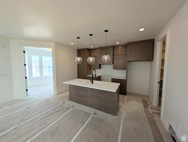 7083 W Granbury Dr S Unit 256, South Jordan, UT 84009 - kitchen featuring dark brown cabinets, a center island with sink, modern cabinets, recessed lighting, and light countertops