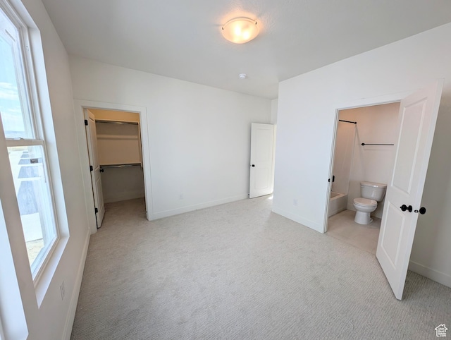 7083 W Granbury Dr S Unit 256, South Jordan, UT 84009 - unfurnished bedroom featuring light colored carpet, a spacious closet, connected bathroom, and a closet