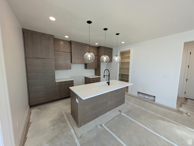 7083 W Granbury Dr S Unit 256, South Jordan, UT 84009 - kitchen with concrete floors, a center island with sink, modern cabinets, recessed lighting, and dark brown cabinets