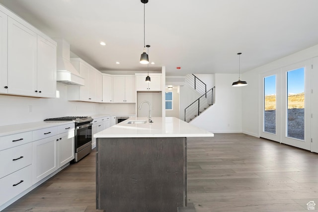6941 W Farnsworth Peak Dr S Unit 316, West Jordan, UT 84081 - kitchen with gas range, custom range hood, wood finished floors, white cabinetry, and a kitchen island with sink