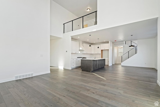 6941 W Farnsworth Peak Dr S Unit 316, West Jordan, UT 84081 - unfurnished living room with a high ceiling, wood finished floors, stairs, and recessed lighting