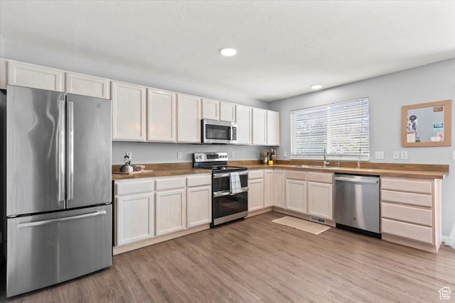 597 E 700 N, Tooele, UT 84074 - kitchen with stainless steel appliances, light wood-type flooring, recessed lighting, and white cabinets