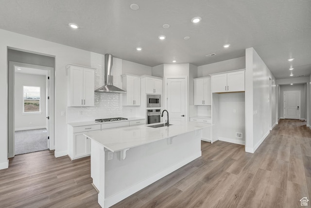 6199 W Wapiti Ridge Ln Unit 333, Herriman, UT 84096 - kitchen featuring wall chimney exhaust hood, appliances with stainless steel finishes, a kitchen island with sink, white cabinets, and recessed lighting