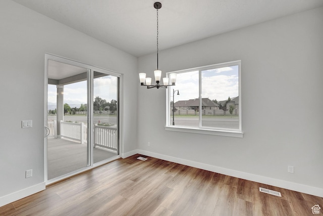 6199 W Wapiti Ridge Ln Unit 333, Herriman, UT 84096 - unfurnished dining area featuring healthy amount of natural light, a chandelier, and wood finished floors