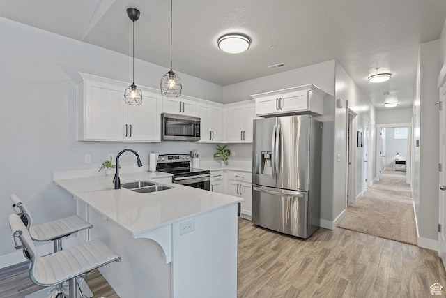 14642 S Mckellen Dr Unit C303, Herriman, UT 84096 - kitchen featuring stainless steel appliances, light countertops, a peninsula, a kitchen breakfast bar, and white cabinets