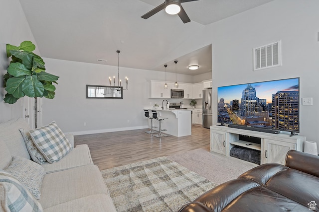14642 S Mckellen Dr Unit C303, Herriman, UT 84096 - living area featuring a chandelier, light wood-type flooring, lofted ceiling, and a ceiling fan