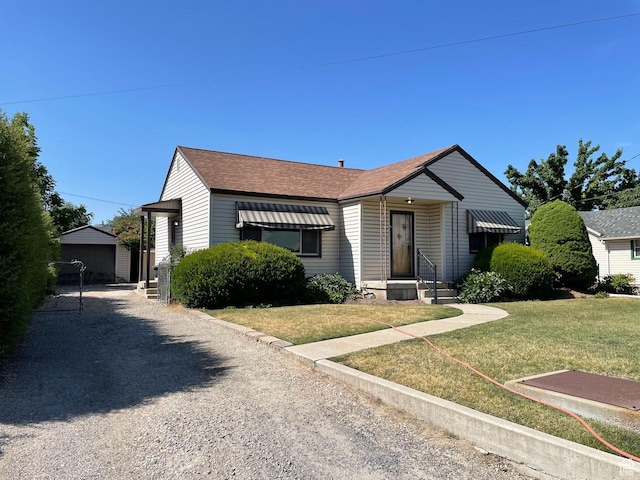 115 W Lester Ave, Murray, UT 84107 - view of front of property with a front yard, an outdoor structure, a shingled roof, and gravel driveway