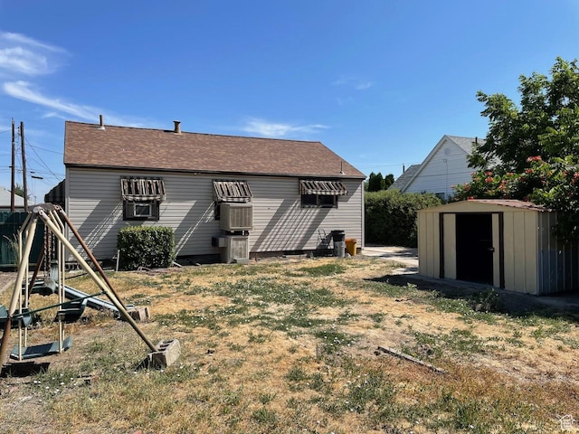 115 W Lester Ave, Murray, UT 84107 - rear view of property featuring a shed, a shingled roof, and a lawn