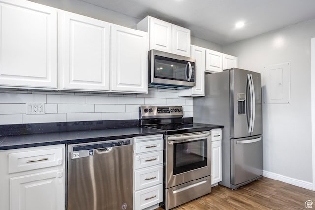 1108 E 6600 S Unit B3, Murray, UT 84121 - kitchen featuring appliances with stainless steel finishes, dark countertops, white cabinetry, dark wood-type flooring, and decorative backsplash