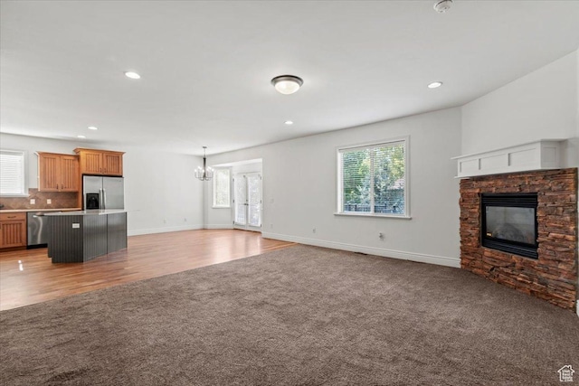 1076 W River Hill Dr, Spanish Fork, UT 84660 - unfurnished living room with light carpet, a fireplace, healthy amount of natural light, and recessed lighting