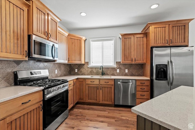 1076 W River Hill Dr, Spanish Fork, UT 84660 - kitchen featuring appliances with stainless steel finishes, light wood-type flooring, backsplash, recessed lighting, and light stone countertops