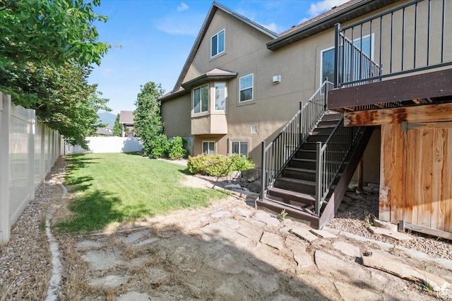 1076 W River Hill Dr, Spanish Fork, UT 84660 - rear view of house with stucco siding, a fenced backyard, and stairway