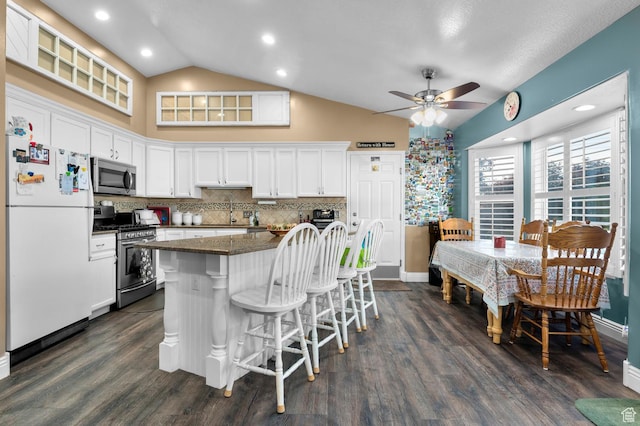 302 W 730 S, Tooele, UT 84074 - kitchen with appliances with stainless steel finishes, vaulted ceiling, a breakfast bar area, ceiling fan, and white cabinets