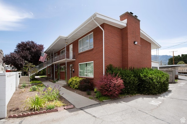 2260 E Murray Holladay Rd S Unit 22, Holladay, UT 84117 - view of home's exterior with brick siding, a chimney, and stairway